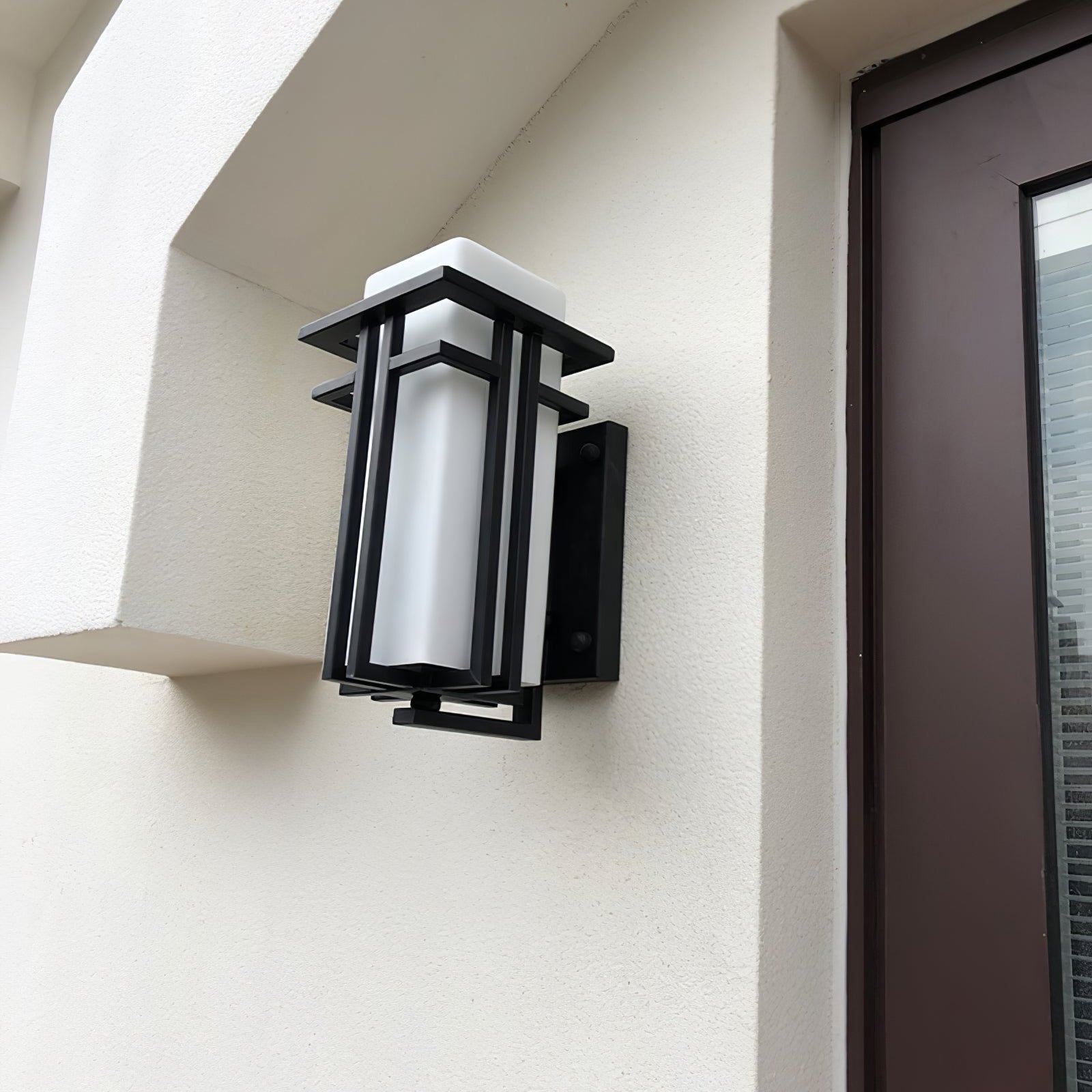 Modern utomhusvägglampa med rektangulär glasskärm och metallram för utomhusbelysning